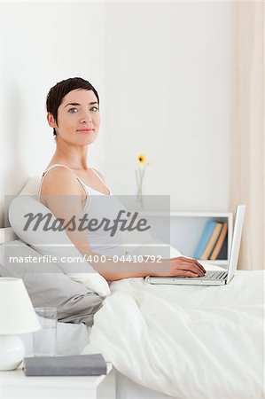 Portrait of a cute woman using a laptop while looking at the camera