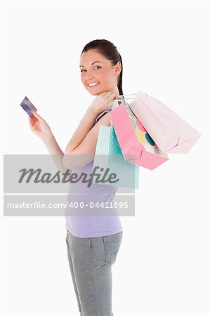 Beautiful woman with a credit card holding shopping bags while standing against a white background