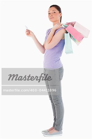 Good looking woman with a credit card holding shopping bags while standing against a white background