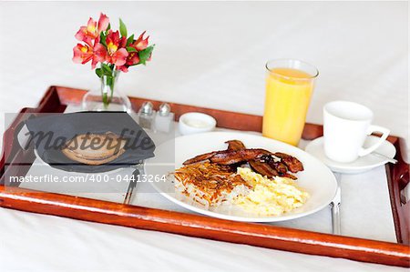 delicious breakfast served on the tray on the hotel room bed