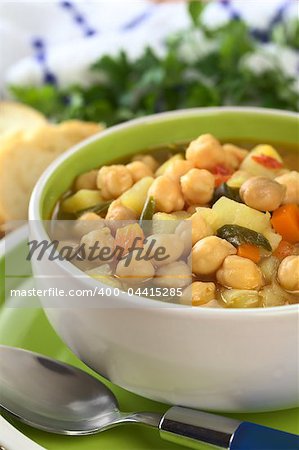 Vegetarian chickpea soup with carrots, potatoes, onions and leek (Selective Focus, Focus on the row of chickpeas in the front of the soup)