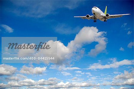 Air travel - Plane flying in blue and cloudy sky.