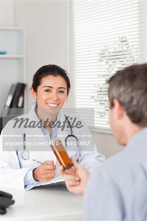 Patient holding a box of pills given by his doctor in the office