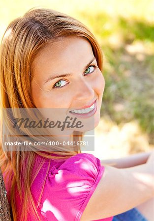 Adorable young woman wearing pink t-shirt and posing in the park