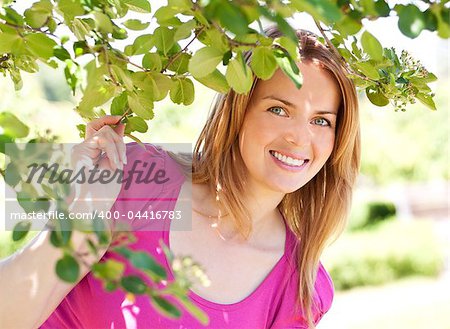 Adorable young woman wearing pink t-shirt and posing in the park