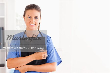 Smiling nurse holding a folder while looking at the camera