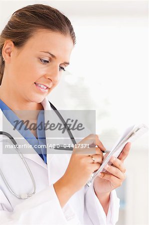 Close up of a brunette doctor writing something down in the surgery