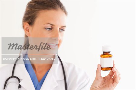 Portrait of a smiling doctor looking at some pills in the surgery