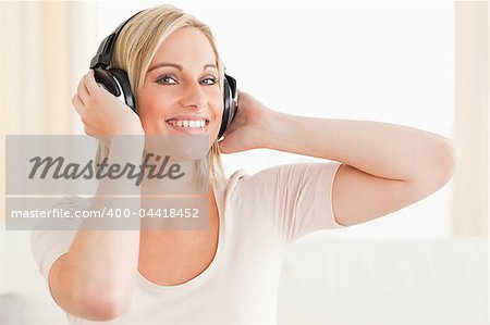 Close up of a cute woman enjoying some music while looking at the camera