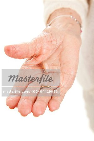 Closeup view of a hearing aid in the hand of a senior woman.