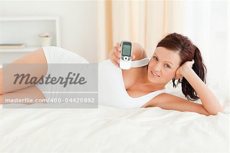 Woman showing a mobile in her bedroom