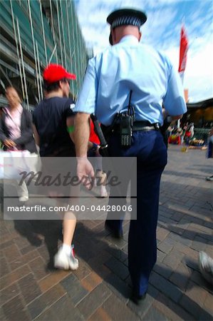 cop in blue uniform arresting or investigating a young man, picture is motion blured