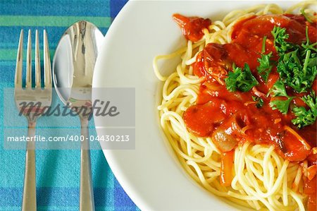 Plate of spaghetti with tomato sauce on a white plate.
