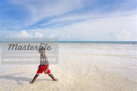 A young African American Boy playing on a white sands beach. Bahia Honda, Florida Keys.