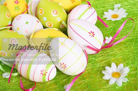 Closeup of several Easter eggs over green artifial grass.