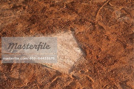 A closeup of a battered home plate at a baseball diamond.
