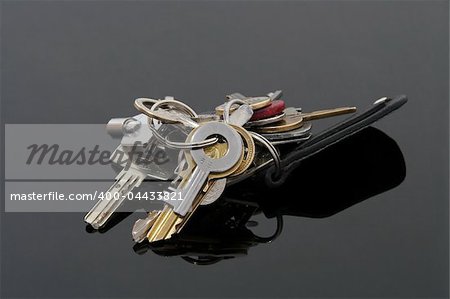 bunch of silver and golden keys on black reflective background