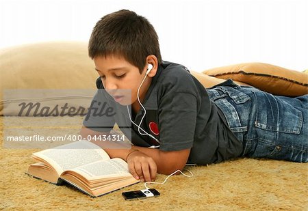 Boy studying laying down and listening with a mp4 player