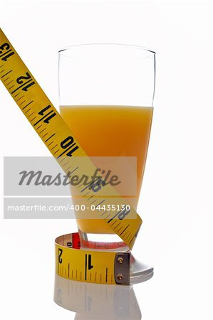 A glass of juice of orange with a metric coiled tape reflected on white background