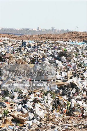 A giant mound of trash in a landfill. All trademarks and logos digitally removed.