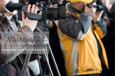 Group of journalists with photo and video cameras shooting some event