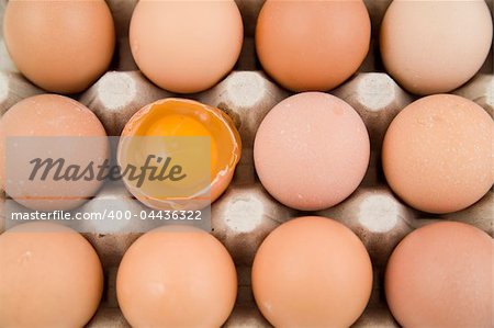 plenty of eggs in paper container. One egg is opened