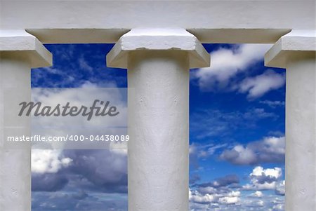 White temple pillars against summery blue sky