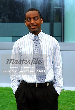 Portrait of a young handsome businessman next to a corporate building