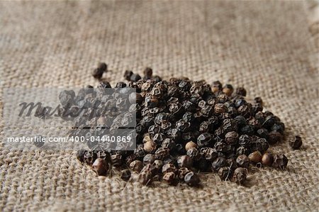 pile of black pepper on a burlap canvas