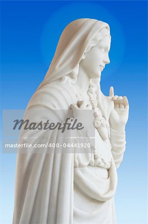 beatiful white statue of Virgin Mary on blue background