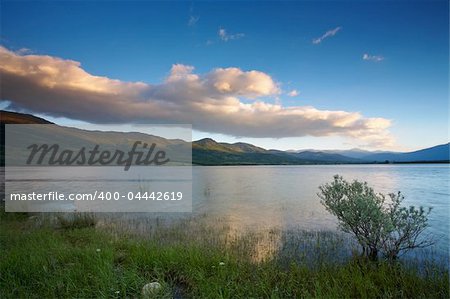 Cloudy sunset over the peaceful lake on spring