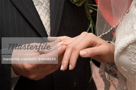 The groom puts on a wedding ring to finger of the beloved