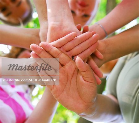 Hands of diverse group of teenagers joined in union