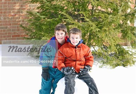 Boys Sitting a large Snowball