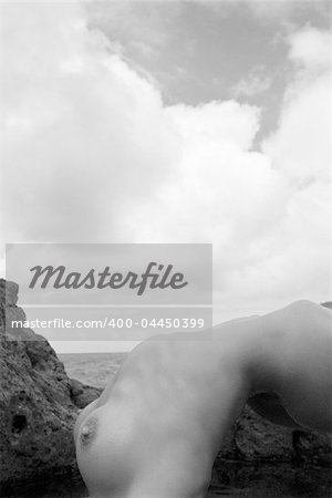 Sexy nude Caucasian woman doing backbend on beach in Maui, Hawaii.