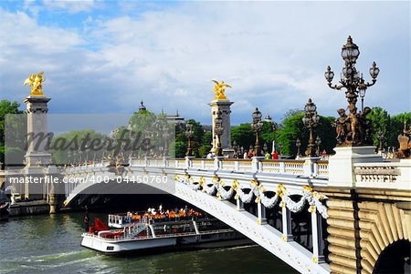 Alexander the Third bridge and Seine cruise boat in Paris, France.