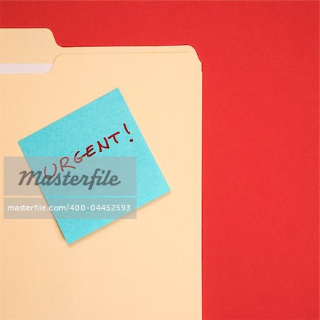 Folder with a blue sticky note attached reading urgent on a red background.
