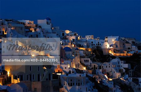 Image shows the village of Oia at dusk, on the beautiful island of Santorini, Greece
