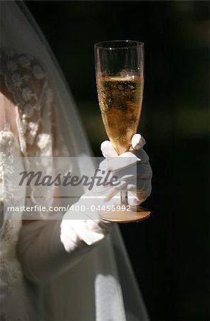 Glass of champagne in a hand of the bride