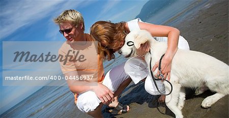 young couple petting dog on the beach vancouver
