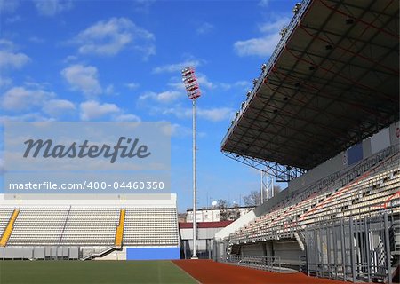 Emty tribunes on a soccer stadium under bright sky