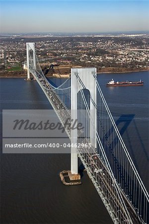 Aerial view of New York City's Verrazano-Narrow's bridge with tanker ship in water.