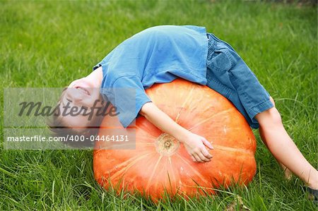 Boy Playing on top of a Huge Pumpkin