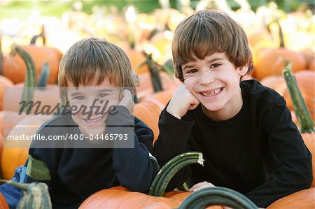 Boys Resting on a Pumpkin in the Pumpking Patch