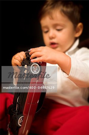 little boy playing indoor with model cars