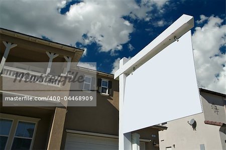 Blank Real Estate Sign with Clouds, Sky and New Home Background - Ready for your own message.