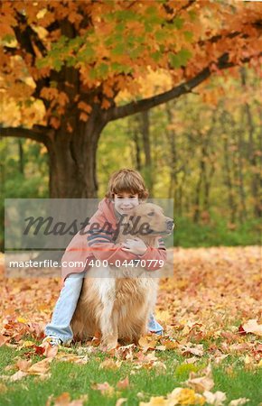 Boy Giving Golden Retriever a Hug under a Beautiful Fall Tree