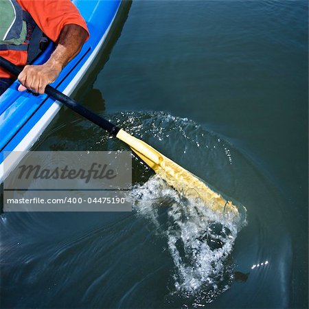 African American male arm paddling kayak.