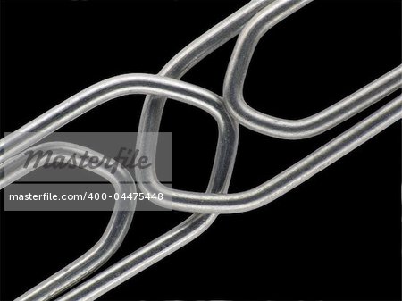 Two linked paperclips on a black background