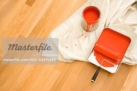 High angle view of painting supplies on drop cloth on wood floor.